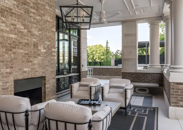 a view of a patio with dining table and chairs with couches and wooden fence