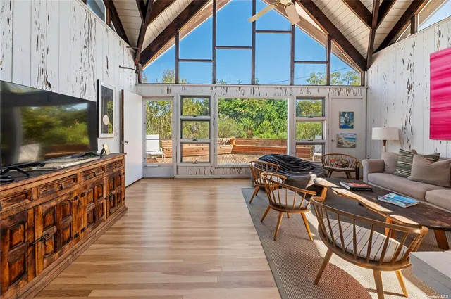 a living room with furniture a flat screen tv and a floor to ceiling window