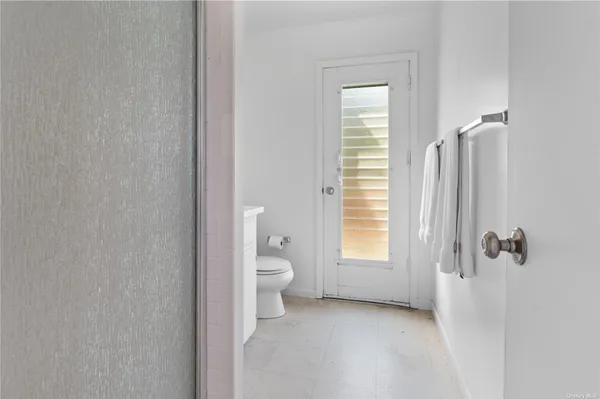 a bathroom with a toilet sink a window and shower