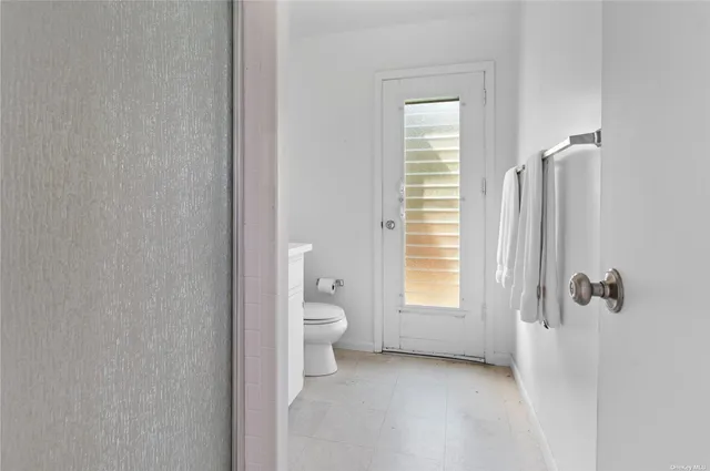 a bathroom with a toilet sink a window and shower