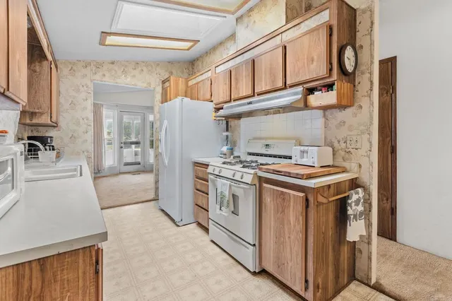 a kitchen with stainless steel appliances granite countertop a stove and a refrigerator