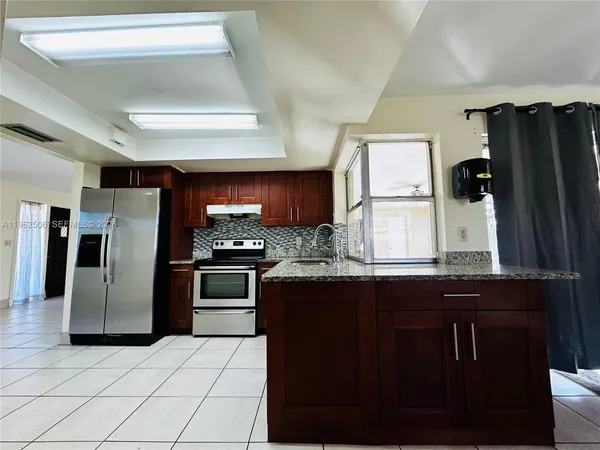 a view of a refrigerator in kitchen and entryway