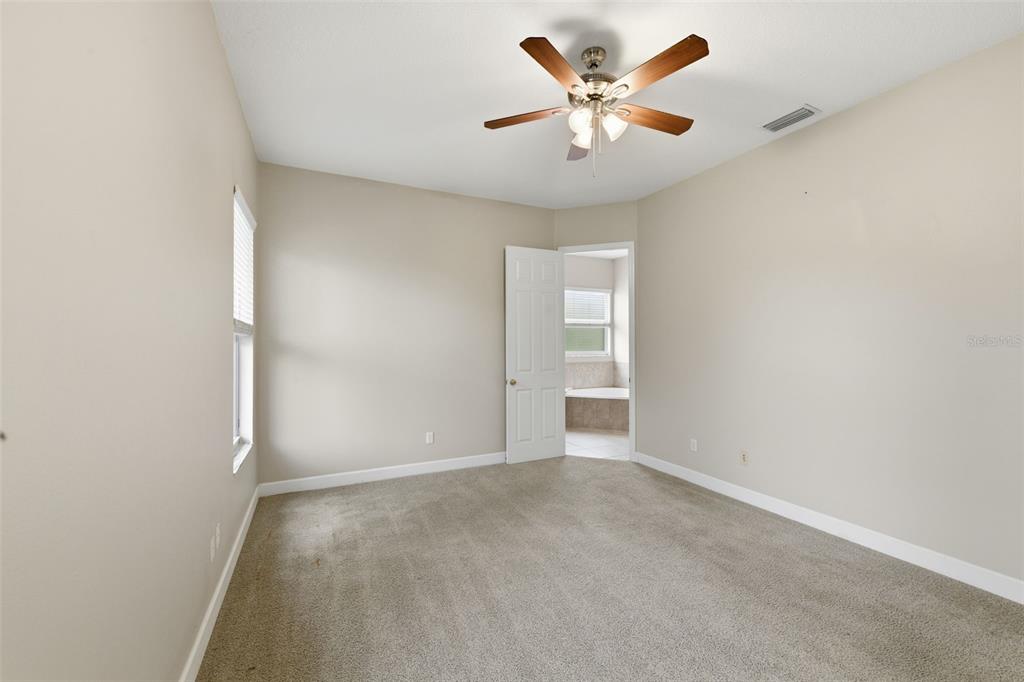 609 Renner Road Port Orange, FL 32127 - Photo 16 of 37 an empty room with a chandelier fan and windows