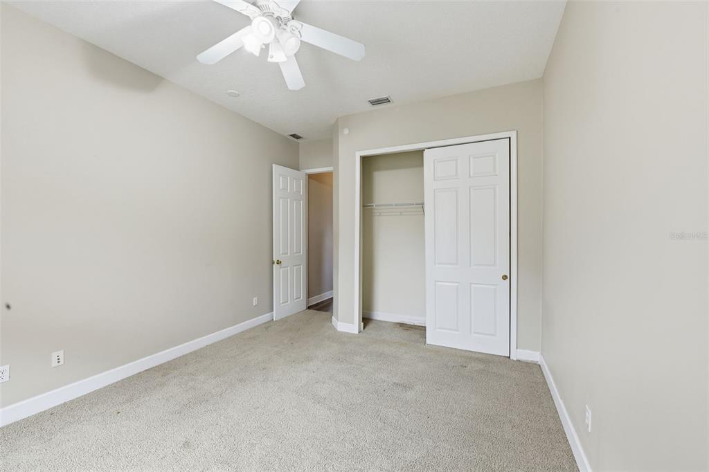 609 Renner Road Port Orange, FL 32127 - Photo 21 of 37 an empty room with chandelier fan and closet area