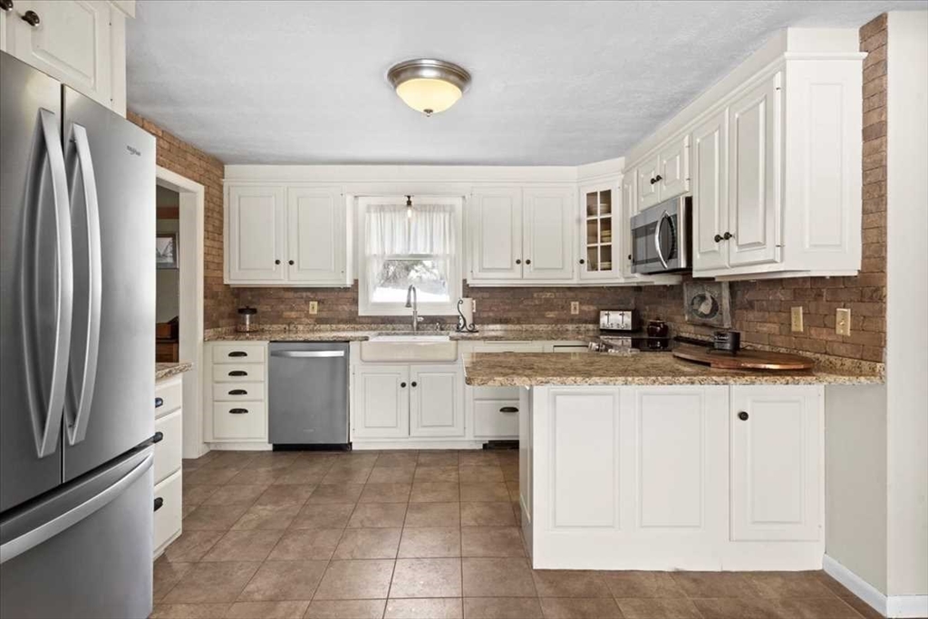 136 Winthrop Lane Holden, MA 01520 - Photo 7 of 42 a kitchen with stainless steel appliances granite countertop a refrigerator sink and cabinets