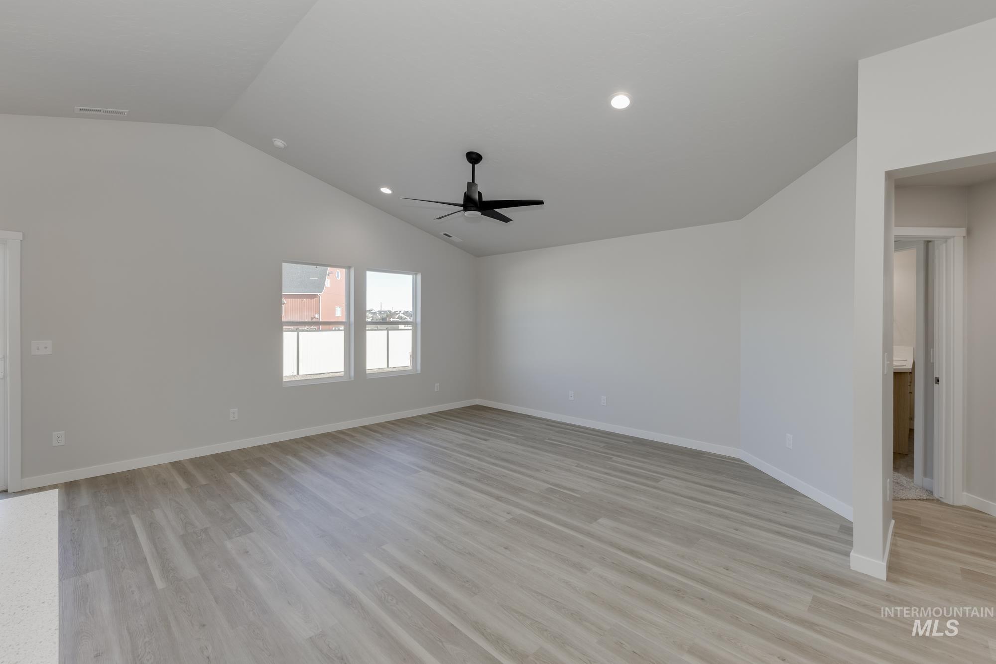 13337 Scrape Street Caldwell, ID 83607 - Photo 3 of 19 Spacious room featuring vaulted ceilings, light wood-finish flooring, recessed lighting, a ceiling fan, and multiple windows