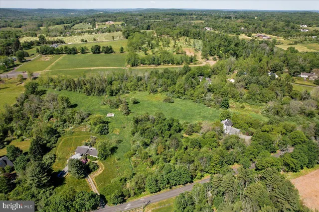 an aerial view of a houses with a lush green hillside
