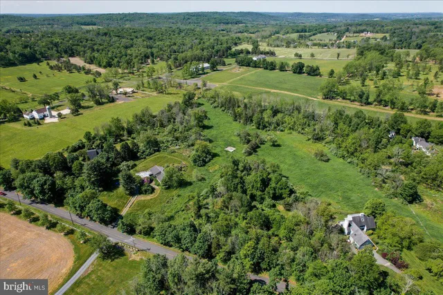 an aerial view of residential houses with outdoor space and trees all around