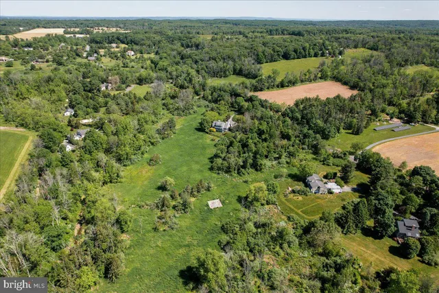 an aerial view of a house with a lush green forest