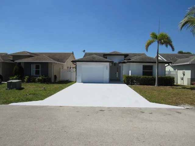 front view of a house with a yard and a car parked