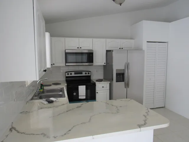 a kitchen with a refrigerator and a stove top oven