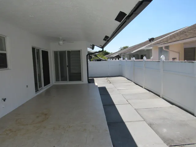 a front view of a house with a yard and palm trees