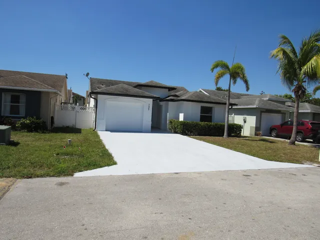 a front view of a house with a garden and patio