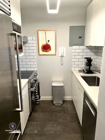 a view of a refrigerator and microwave in a kitchen