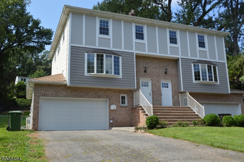 89 Forsythia Lane, Unit A Paramus, NJ 07652 - Photo 1 of 20 a front view of a house with a yard and garage