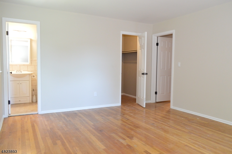 89 Forsythia Lane, Unit A Paramus, NJ 07652 - Photo 12 of 20 an empty room with wooden floor and windows