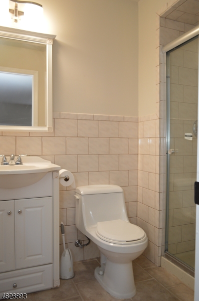 89 Forsythia Lane, Unit A Paramus, NJ 07652 - Photo 13 of 20 a bathroom with a toilet sink and mirror