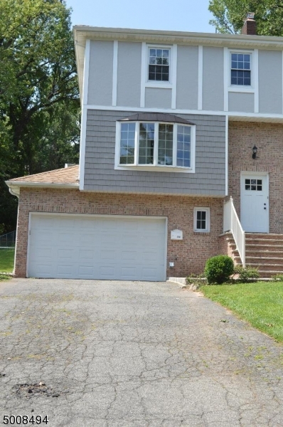 89 Forsythia Lane, Unit A Paramus, NJ 07652 - Photo 20 of 20 a front view of a house with a yard and garage