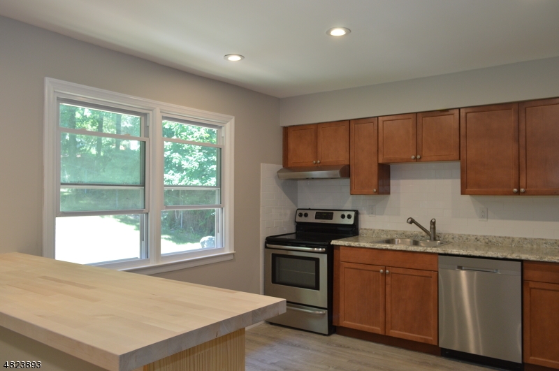 89 Forsythia Lane, Unit A Paramus, NJ 07652 - Photo 2 of 20 a kitchen with granite countertop a stove a sink and a cabinets