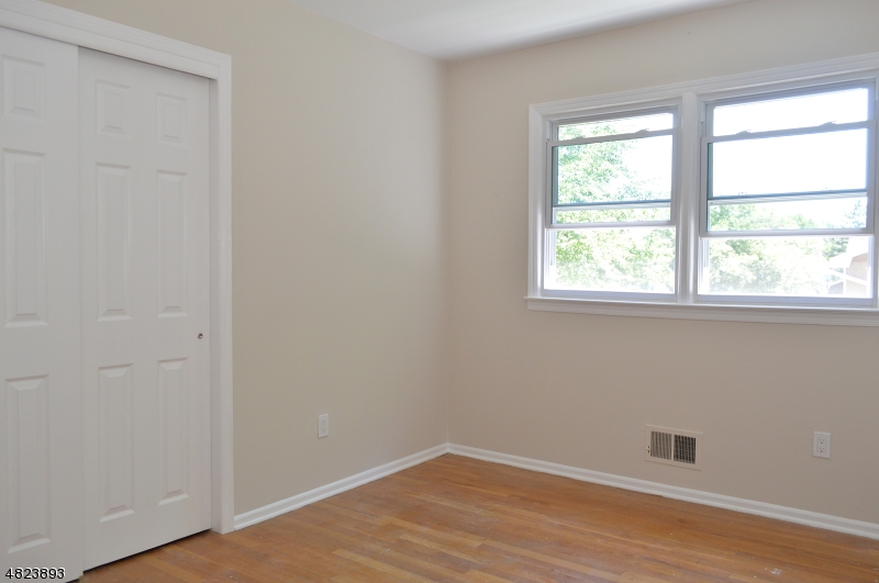 89 Forsythia Lane, Unit A Paramus, NJ 07652 - Photo 9 of 20 an empty room with wooden floor and a window