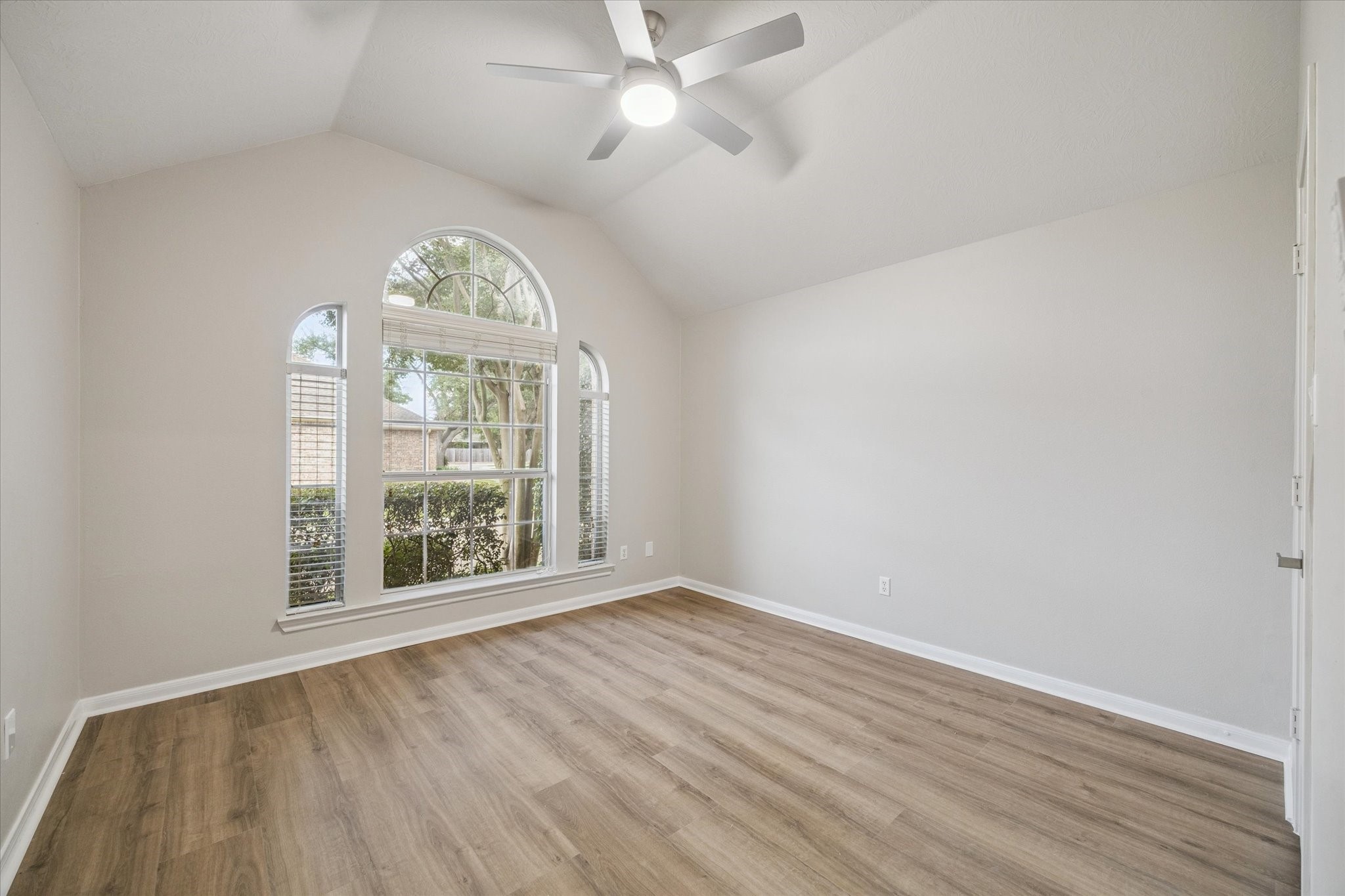 18747 Candle Park Drive Spring, TX 77388 - Photo 24 of 32 an empty room with wooden floor fan and windows