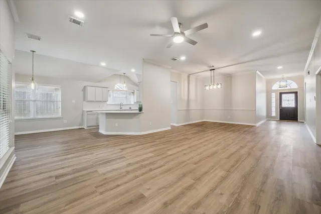 a view of an empty room and a kitchen