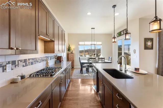 a kitchen with stainless steel appliances a sink a stove and a wooden floors