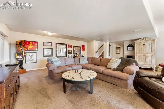 a living room with furniture a rug and a wall painting