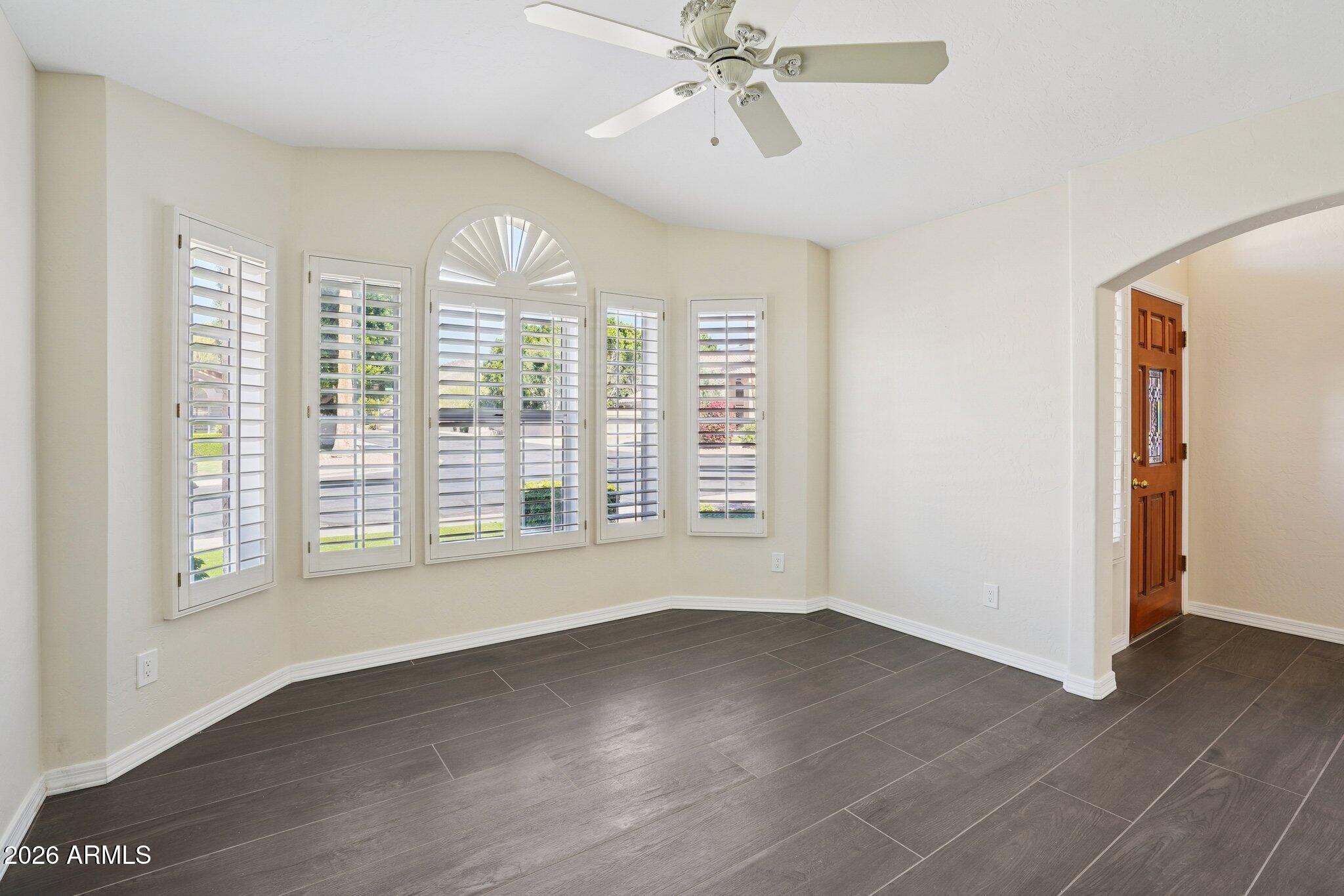 6303 West Melinda Lane Glendale, AZ 85308 - Photo 10 of 26 a view of an empty room with a window and wooden floor