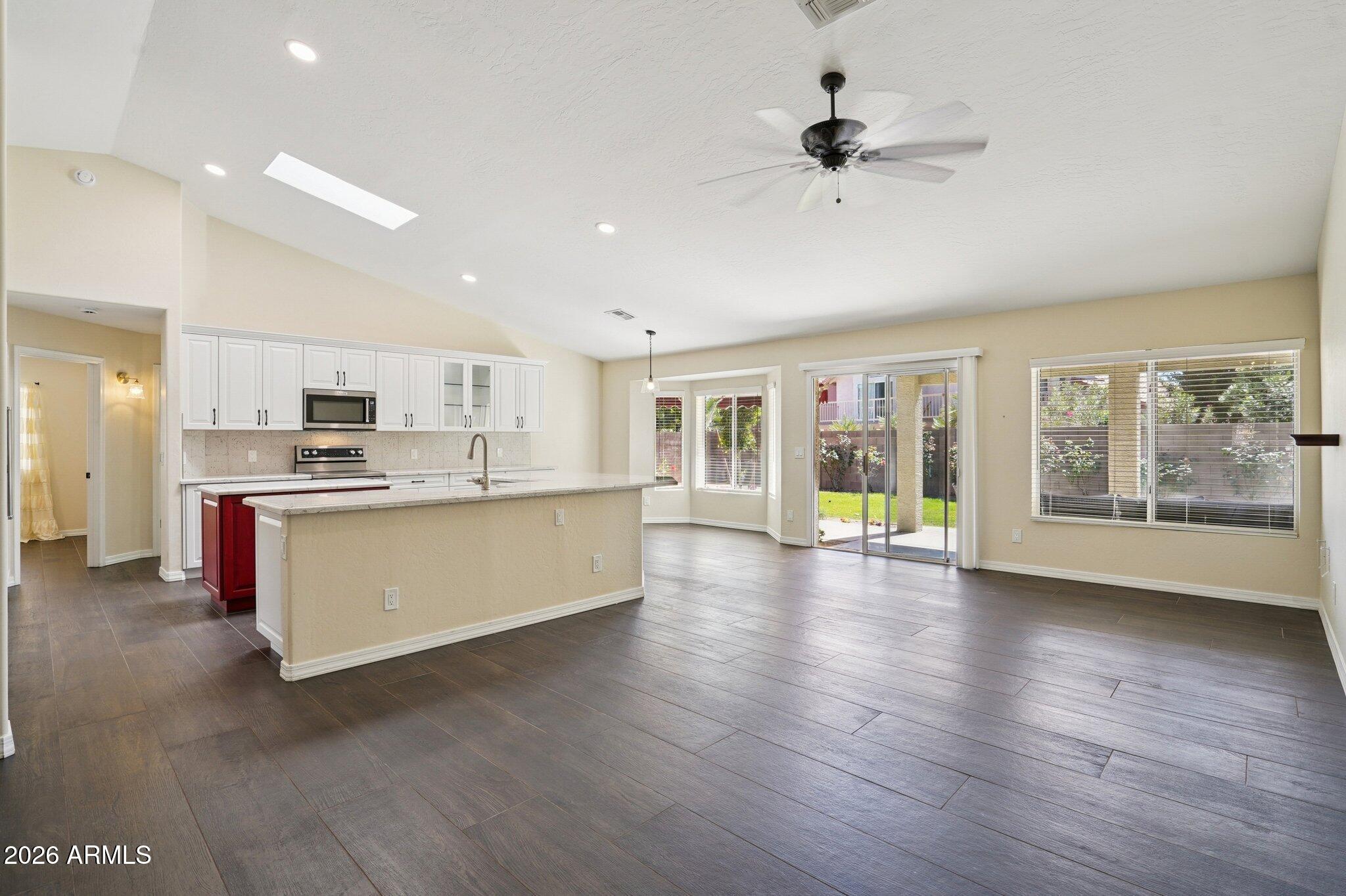 6303 West Melinda Lane Glendale, AZ 85308 - Photo 11 of 26 a view of kitchen with stainless steel appliances kitchen island wooden floors and living room view