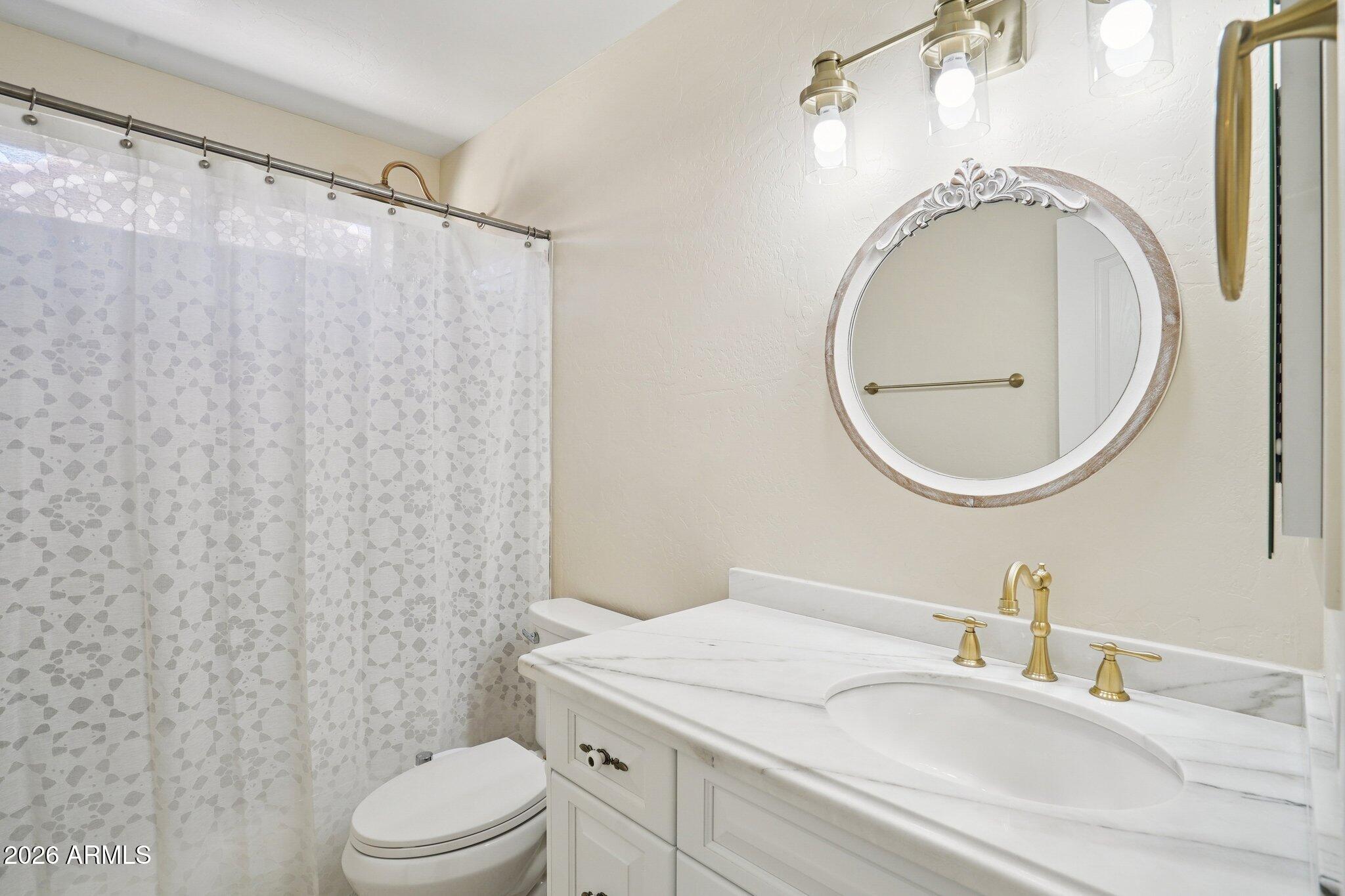 6303 West Melinda Lane Glendale, AZ 85308 - Photo 17 of 26 a bathroom with a granite countertop sink mirror vanity and toilet