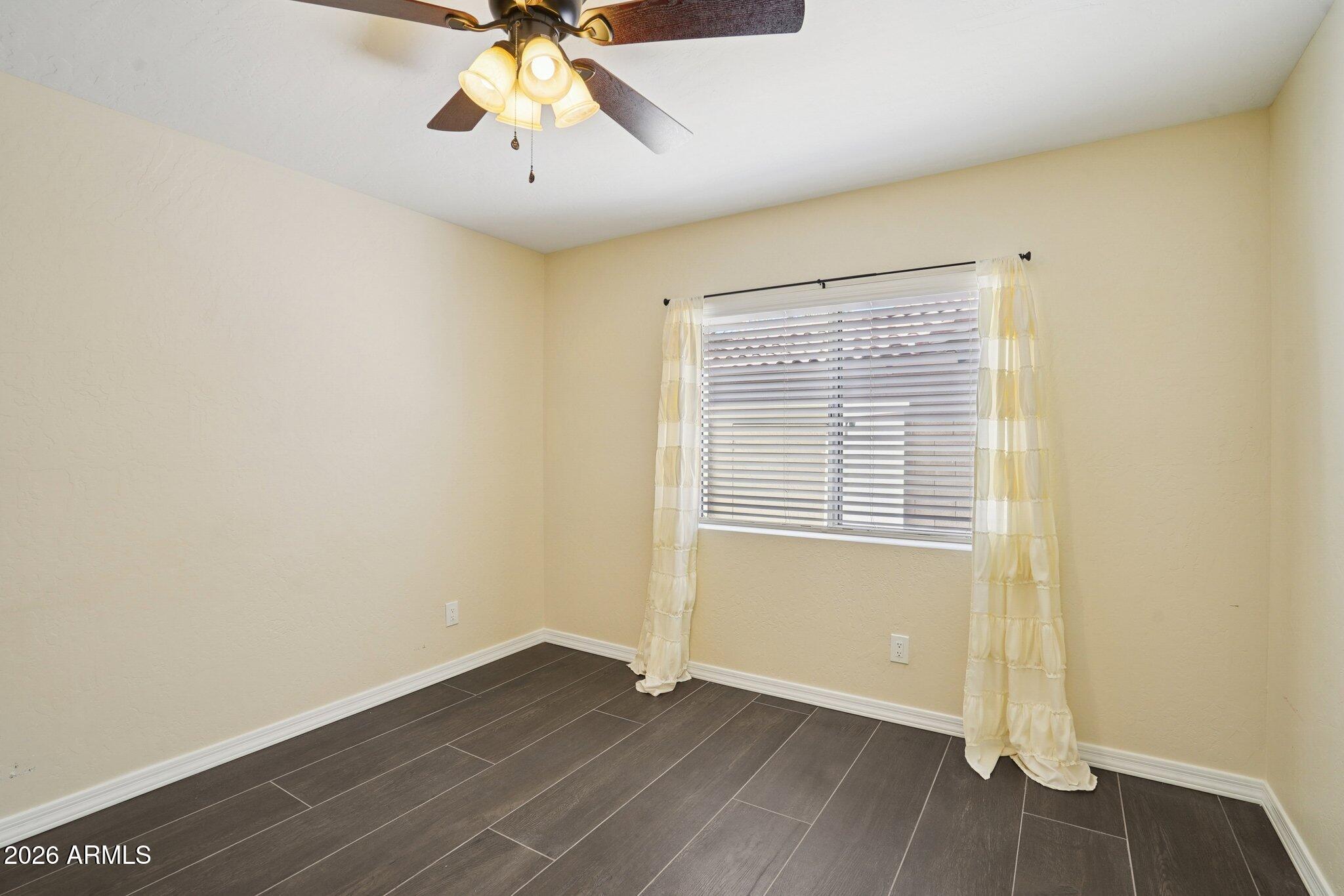 6303 West Melinda Lane Glendale, AZ 85308 - Photo 18 of 26 an empty room with wooden floor and windows