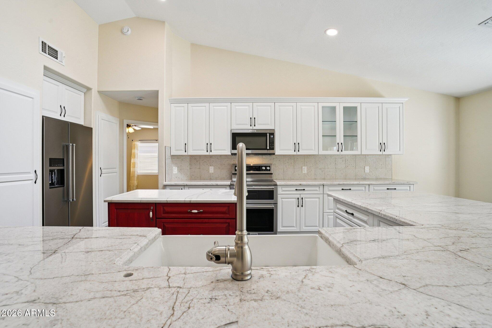 6303 West Melinda Lane Glendale, AZ 85308 - Photo 4 of 26 a kitchen with stainless steel appliances kitchen island granite countertop a refrigerator and a stove top oven