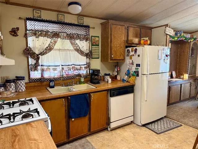 a kitchen with a sink a refrigerator and a stove top oven
