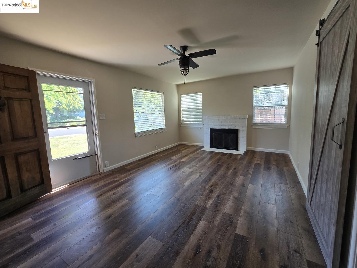 241 Humboldt Street San Rafael, CA 94901 - Photo 15 of 32 an empty room with wooden floor fireplace and windows