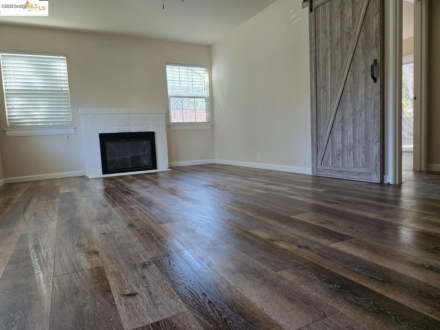 241 Humboldt Street San Rafael, CA 94901 - Photo 21 of 32 an empty room with wooden floor a fireplace and windows