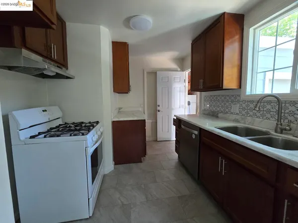 a kitchen with stainless steel appliances granite countertop a stove a sink dishwasher and a refrigerator