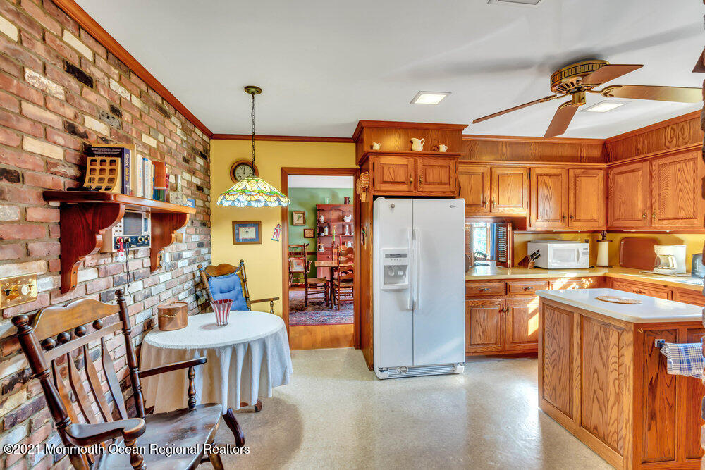 3234 Ridgewood Road Allenwood, NJ 08720 - Photo 7 of 49 a kitchen that has a refrigerator a stove and a dining table with wooden floor