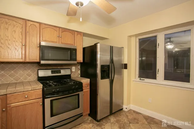 a kitchen with stainless steel appliances a refrigerator stove and microwave