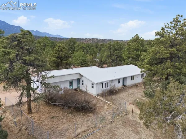 a aerial view of a house with a yard and mountain view in back