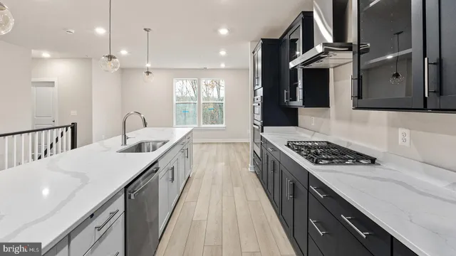a kitchen with kitchen island a counter space a sink a stove and a refrigerator