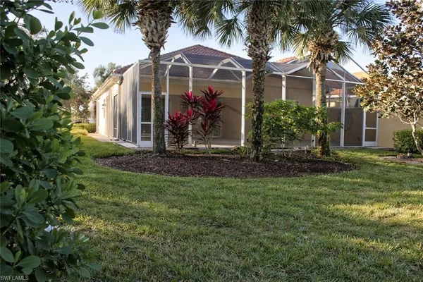 a view of a house with a yard and potted plants