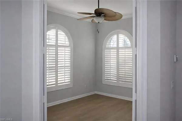a view of a livingroom with a large window ceiling fan and wooden floor