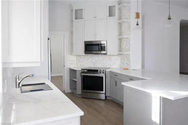a kitchen with granite countertop white cabinets and stainless steel appliances