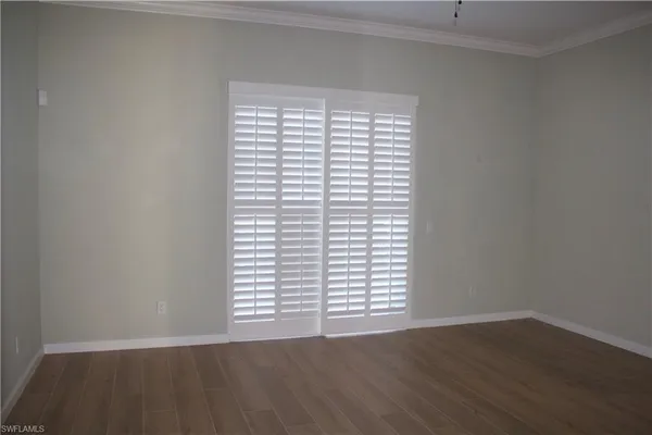 an empty room with wooden floor and a window