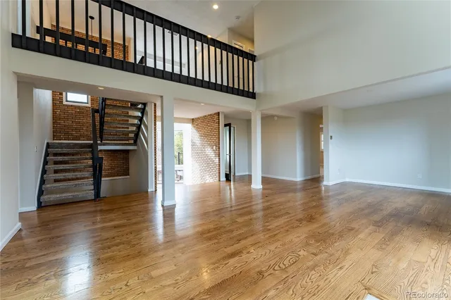 a view of a livingroom with wooden floor and stairs