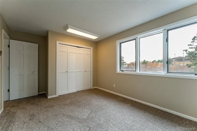 an empty room with windows and closet