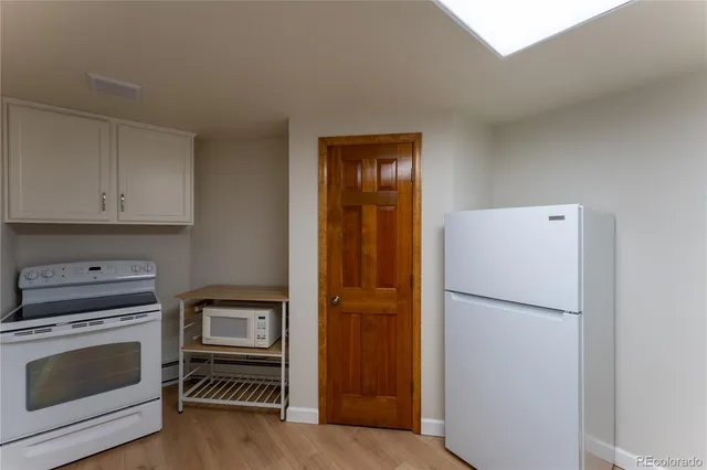 a kitchen with a refrigerator and a stove top oven
