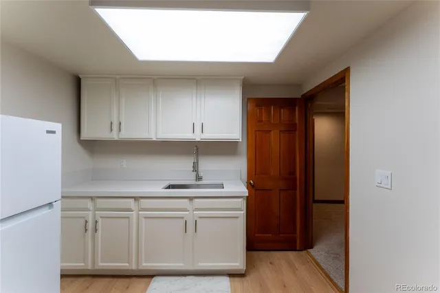 a kitchen with white cabinets and white appliances