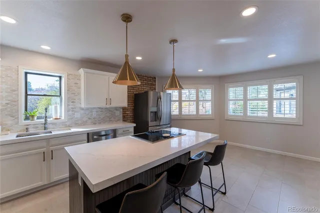 a kitchen with a table chairs sink and wooden floor